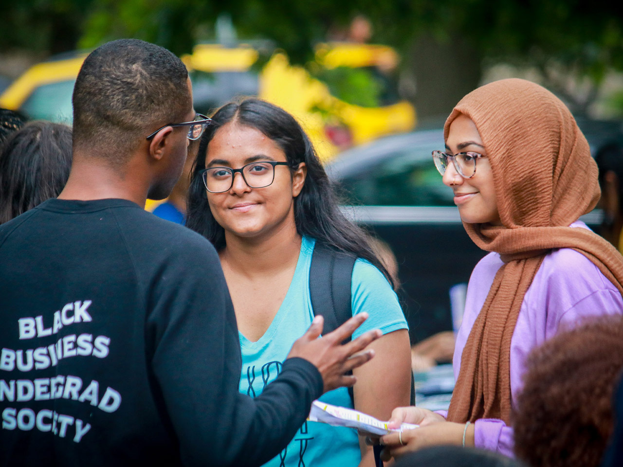 Three students talking outdoors on campus